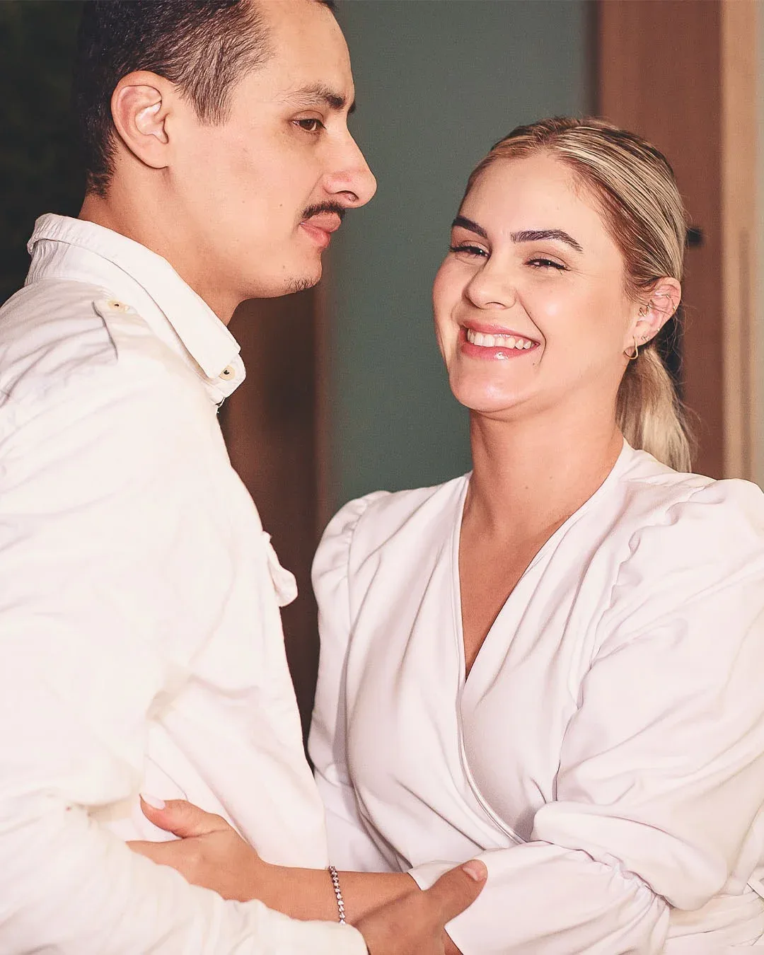 Casal sorrindo durante uma cerimônia de casamento civil.