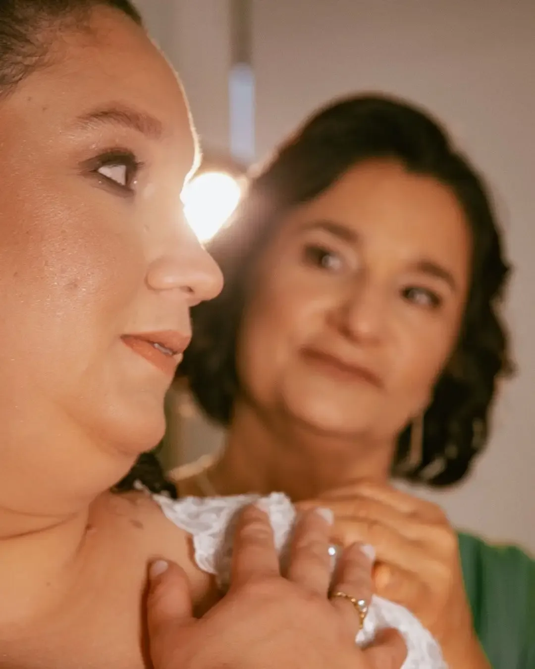 Noiva recebendo ajuda para colocar um brinco.