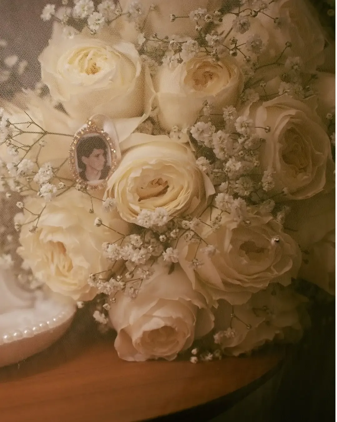 Detalhe de um buquê com rosas brancas e flores pequenas.