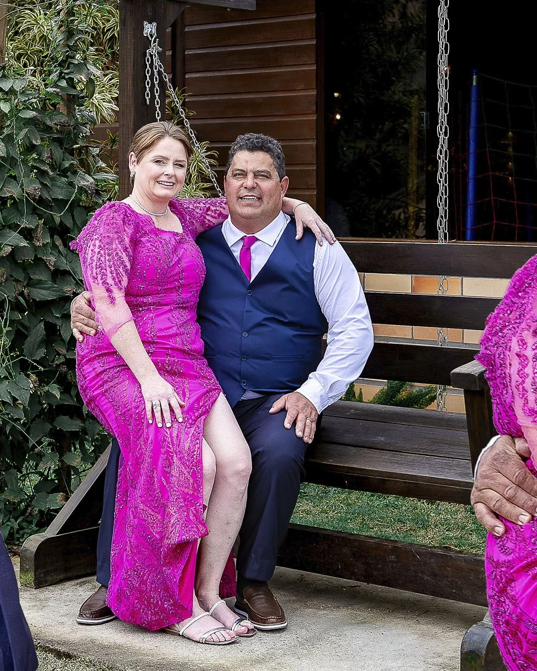 Casal posando junto a um balanço de madeira durante as bodas.